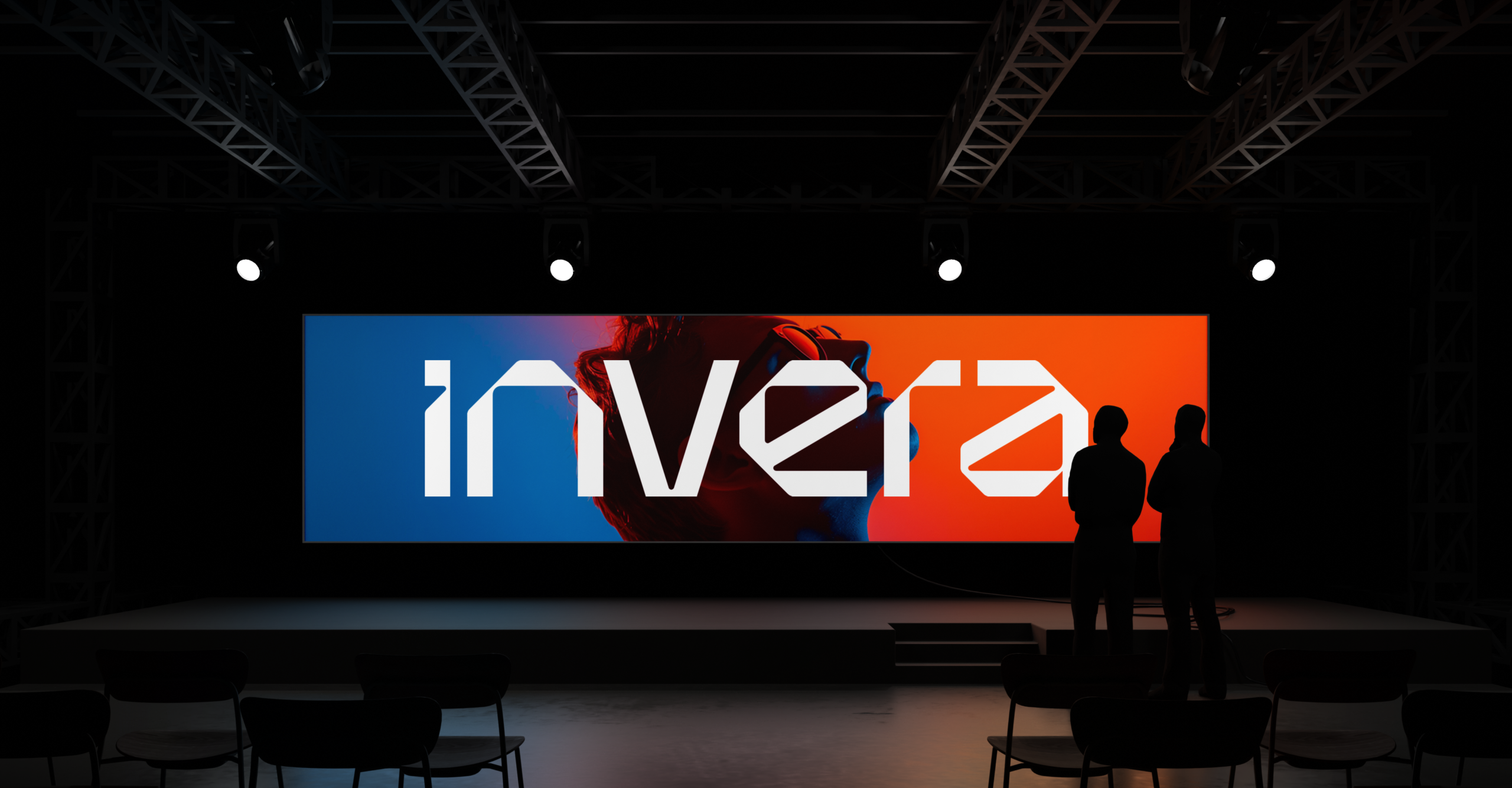 Interior view of a venue presentation where the Invera logo is shown on a large projector screen in a dimly lit hall.